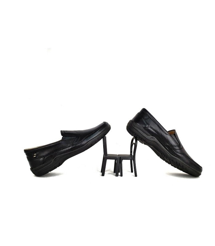 Mocasín de sport fabricado por Lusetti en piel negra, apoyados en una mini silla