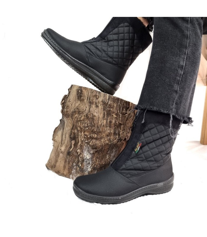 Bota impermeable mujer negra puestas en modelo subida en un tronco