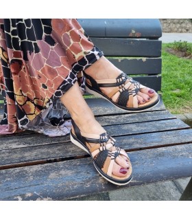 Sandalia como un guante de Confort Class de piel rosa y negro luciéndolas una mujer con vestido estampado