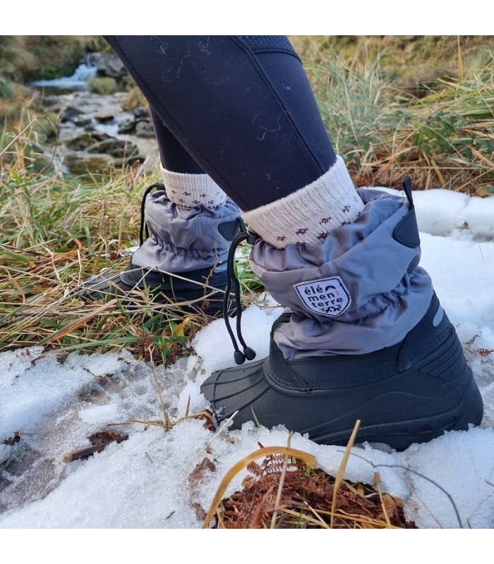 modelo caminando por la nieve con las  Botas apresquí impermeable mujer puestas