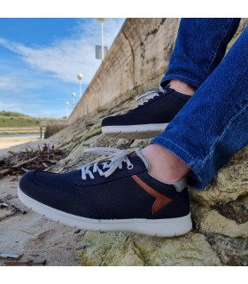 Zapato hombre cordones nobuck azul puesto en un hombre posando en las rocas