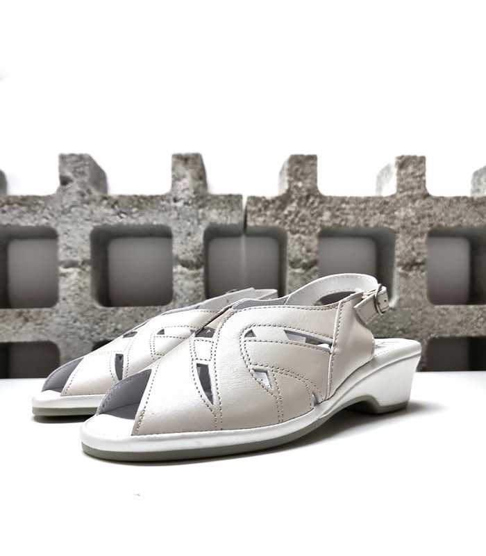 Sandalias mujer piel blanco nacarado con diseño calado y cierre de hebilla, vista en ángulo semiperfil.