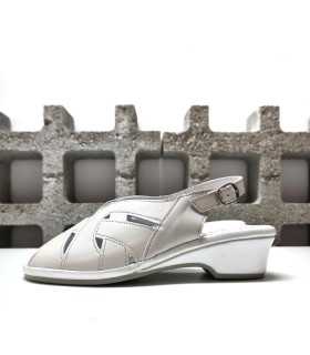 Sandalia piel blanco nacarado de mujer con horma ancha y cuña baja, vista lateral completa.