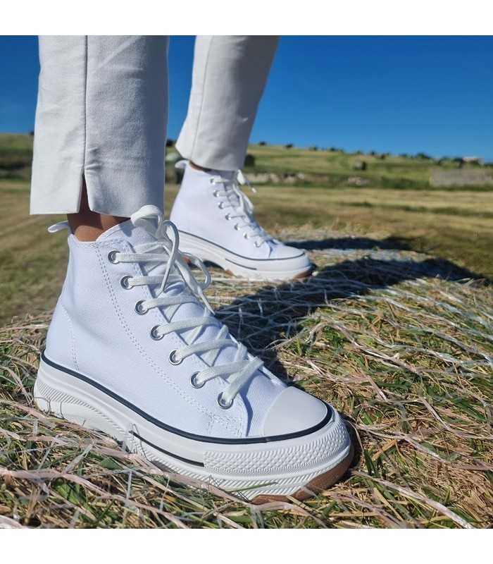 Bota sneaker plataforma lona blanca mujeren mujer posando sobre una paca de paja