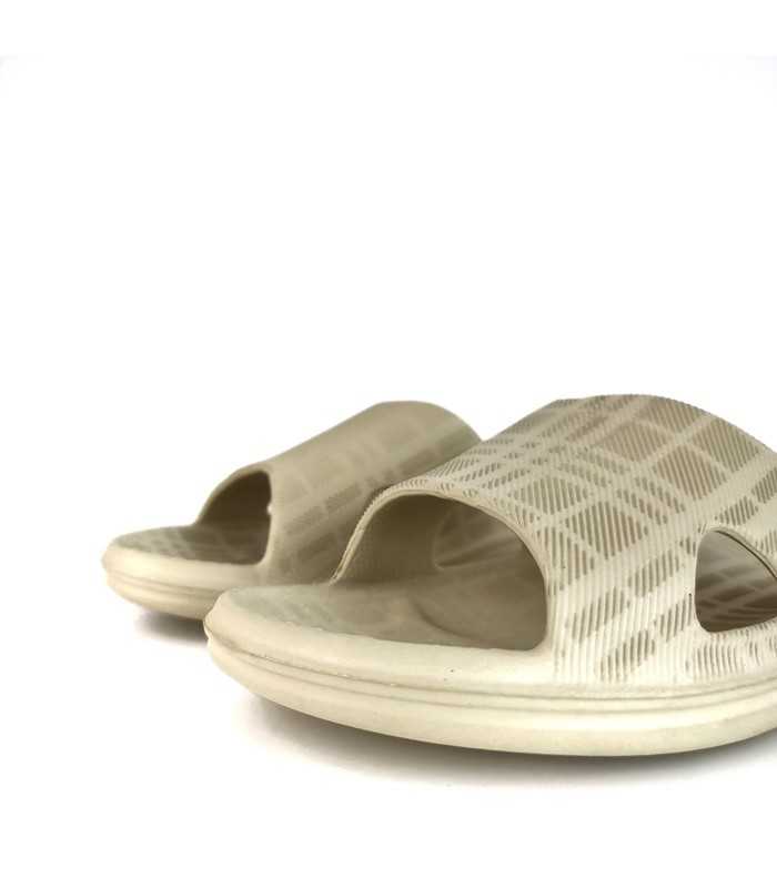 Primer plano de puntera descalza de Chanclas de playa o piscina beige