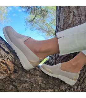 Mujer con los Zapato mocasín cuña beige de Treintas sobre unas ramas.