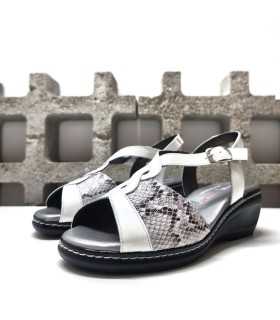 Combinación de piel lisa y textura animal print en sandalia blanca con cuña.