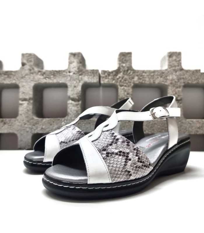 Combinación de piel lisa y textura animal print en sandalia blanca con cuña.