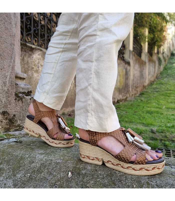 Sandalia plataforma marrón mujer combinada con pantalón de lino puestas en una mujer