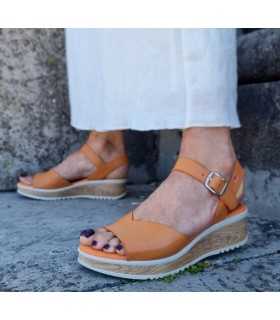 Sandalias Pepe Menargues naranja puestas con falda blanco