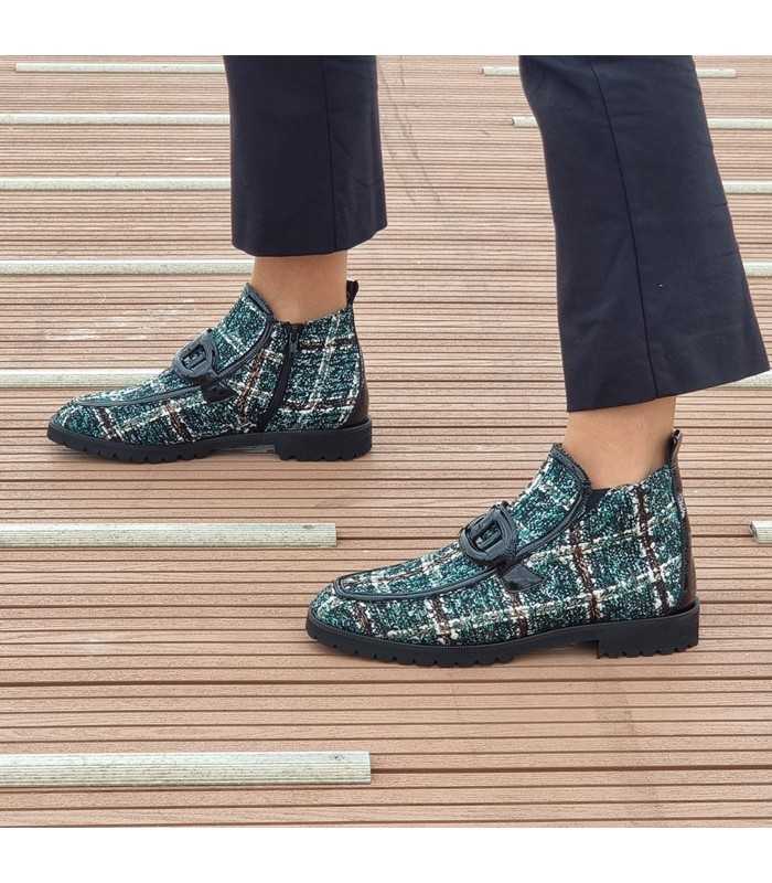 Botín plano verde ABBA de Nival puesto, combinado con pantalones oscuros.