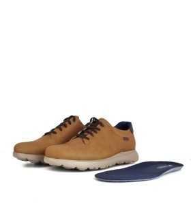 Plantilla anatómica extraida del zapato amarillo junto a los zapatos