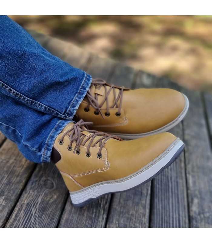 Bota amarilla hombre Garlan-Deno watterproof de Skechers puestas con los pies cruzados.