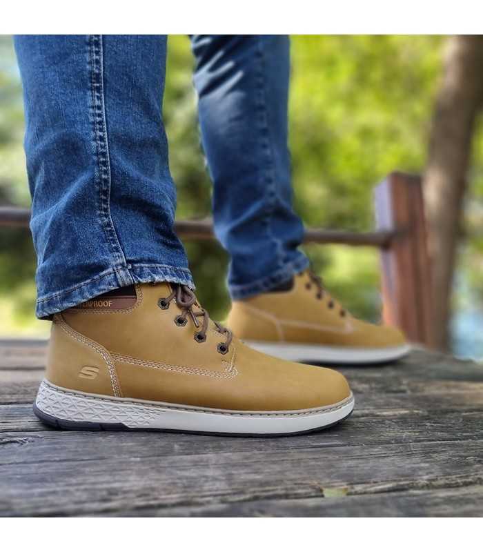 vista letral en la calle de Bota amarilla hombre Skechers luciendolas un modelo