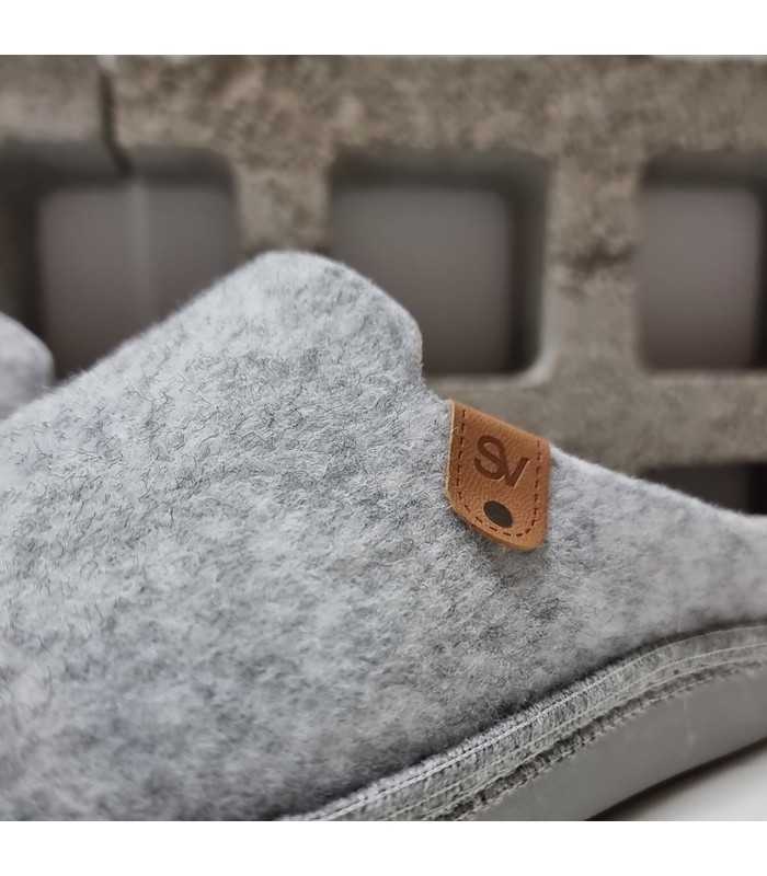 Primer plano del tejido de lana prensada y el forro aterciopelado que aporta calidez en zapatilla gris