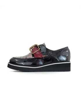Vista lateral negro:
zapatos Carolina en charol negro con hebilla de bronce es perfecto para un look elegante y cómodo.