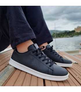 Zapatilla deportiva Court Trainers negras puestas en los pies.