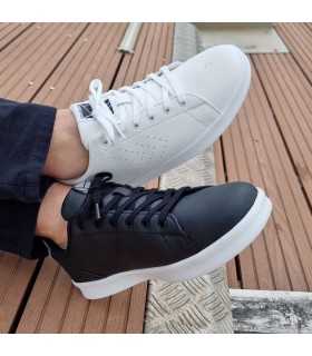 Hombre con zapatillas de hummel negras y blancas puestas