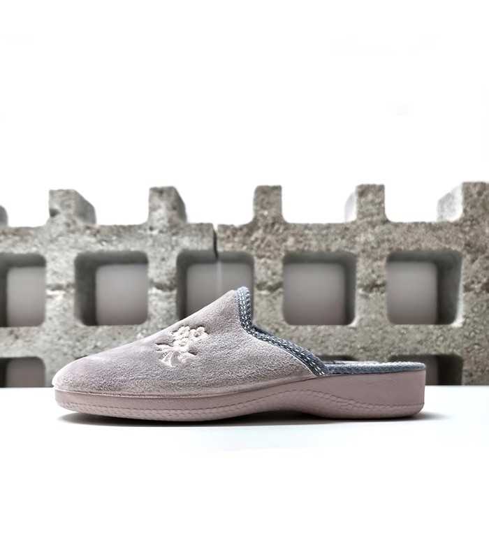 Vista lateral de las zapatillas mostrando el bordado floral sobre el suave tejido rosa.