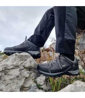 Zapatilla de senderismo Sonora gris de Elementerre en modelo puestas sobre las rocas