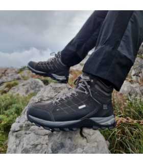 vista lateral de las botas puestas em modelo sobre rocas