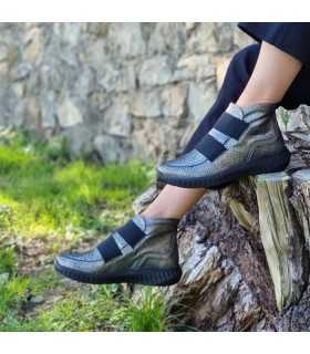 modelo posando sobre un tronco con pantalon negro con los botines  Jarlen de Suave