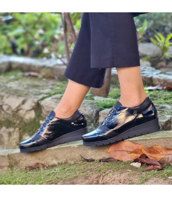 modelo posando con los zapatos de cuña negros de Valerias