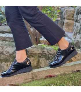 Vista modelo andando con los zapatos negros de charol negros de Valerias