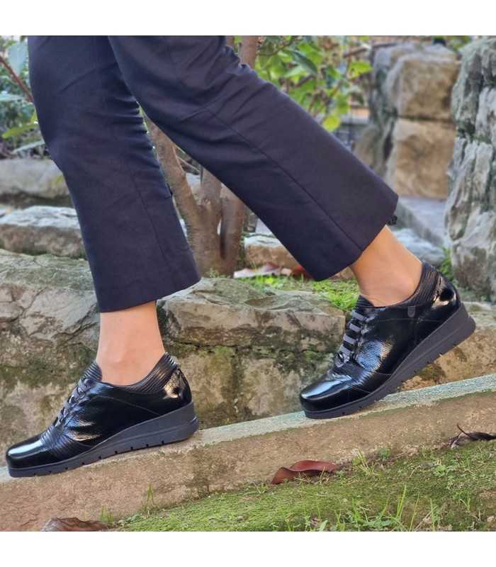 Vista modelo andando con los zapatos negros de charol negros de Valerias