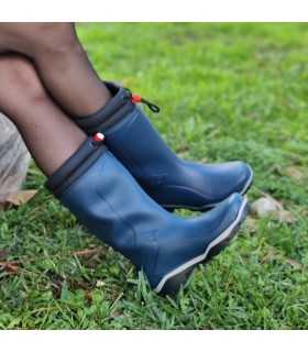 Botas agua mujer alta azul posando con los pies cruzados en la modelo.