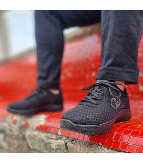 Deportivos Runner negros hombre posando en un banco puestos en un modelo
