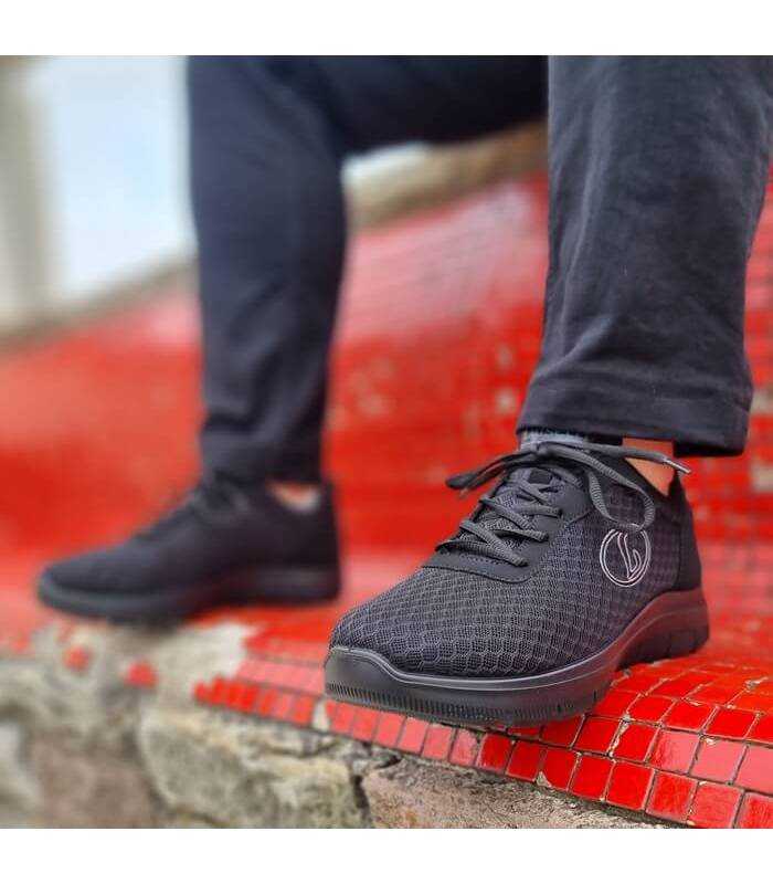 Deportivos Runner negros hombre posando en un banco puestos en un modelo