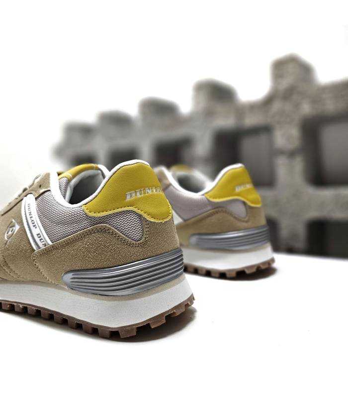 Primer plano del cuello acolchado en las zapatillas beige de Dunlop, ofreciendo mayor comodidad.