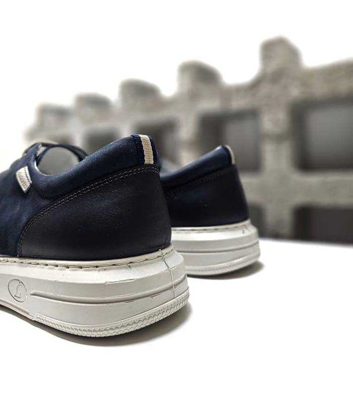 Vista trasera del zapato azul con acabado en napa lisa.