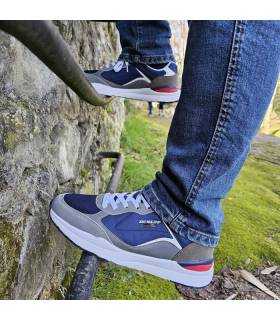hombre posando con los deportivos azules de Dunlop combinado con vaqueros