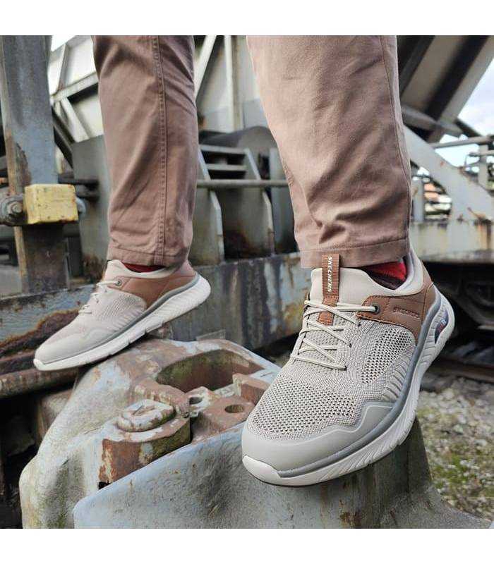 Deportivo hombre Arch Fit Emeric de Skechers combinado con pantalon marrón puestos en modelo