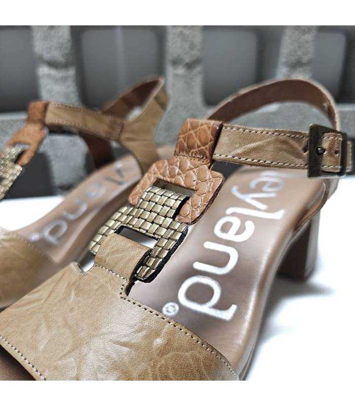 Detalle de piel marron combinada con texturas metalizadas en sandalia de tacón Suave