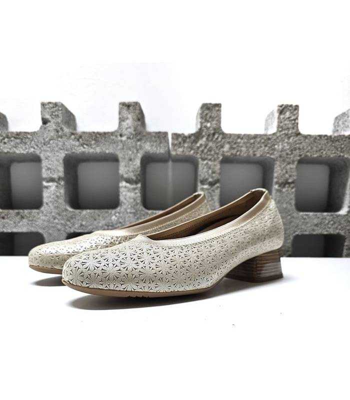 Vista lateral: Diseño elegante y versátil con piel nacarada y tacón bajo de zapato beige