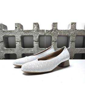Vista lateral: Diseño elegante y versátil con piel nacarada y tacón bajo de zapato blanco