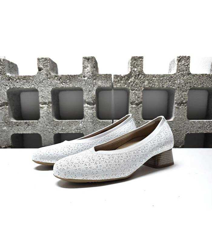 Vista lateral: Diseño elegante y versátil con piel nacarada y tacón bajo de zapato blanco