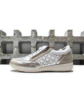 Vista lateral del zapato deportivo de piel blanco y oro Treintas. Diseño troquelado y detalles dorados.