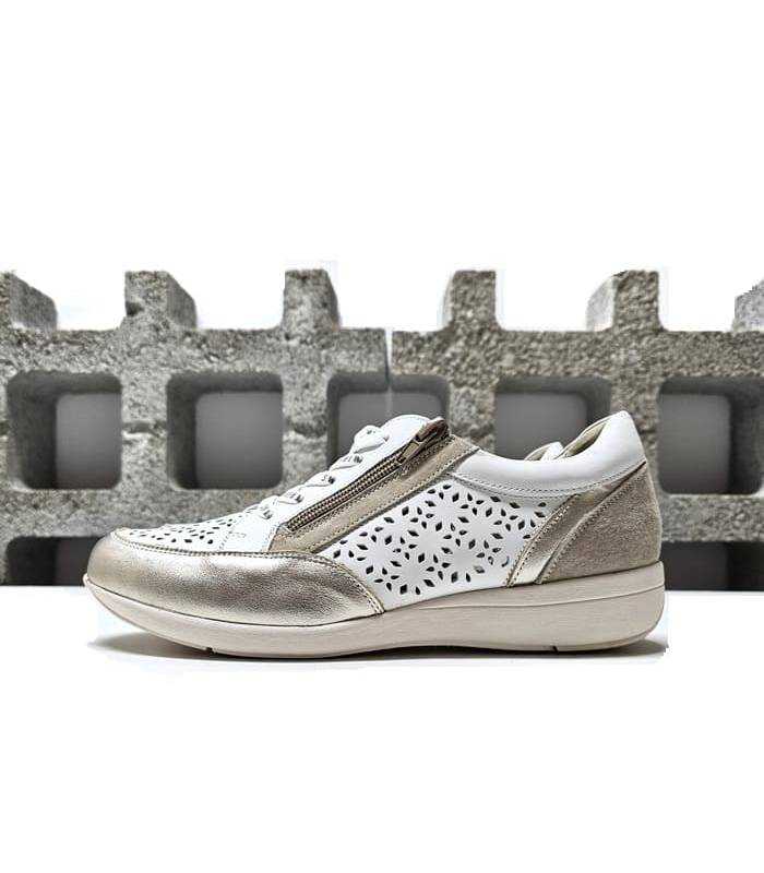 Vista lateral del zapato deportivo de piel blanco y oro Treintas. Diseño troquelado y detalles dorados.