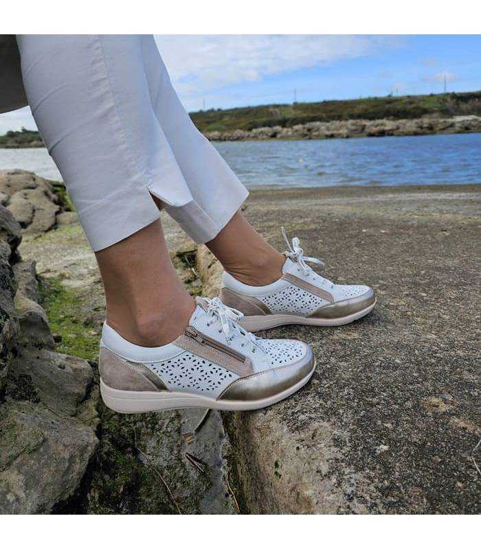 Modelo posando con los zapatos deportivos puestos blanco de Treintas combinado con pantalón Blanco