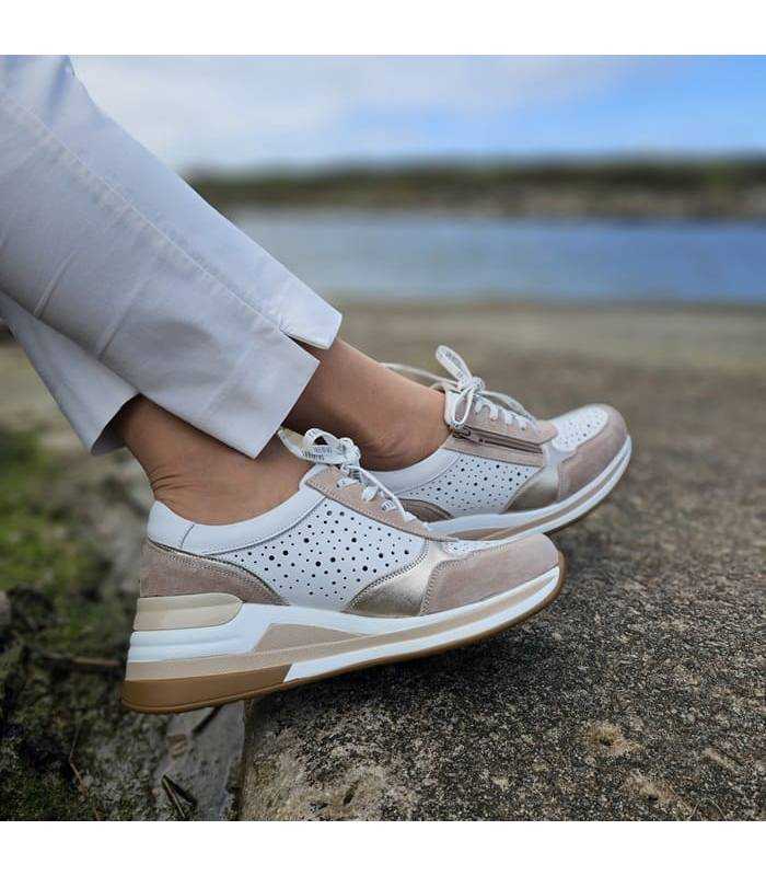 zapatos de mujer con cuña en piel blanca puesto posando con los pies cruzados