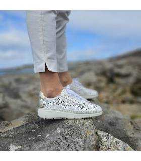 Zapatos de piel blanca torquelada vistos de perfil puestos en modelo