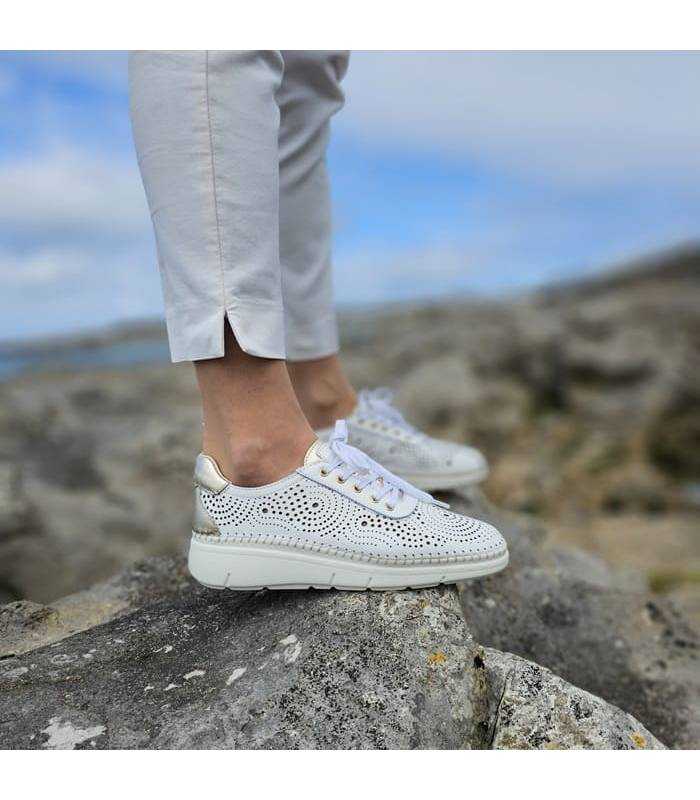Zapatos de piel blanca torquelada vistos de perfil puestos en modelo