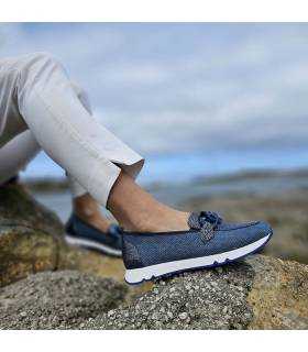 Mujer posando en la costa con los zapatos de horma ancha bonito tipo mocasín azules