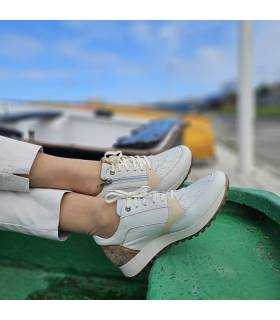 pies cruzados con los zapatos de piel beige con cremallera de Kangaroos