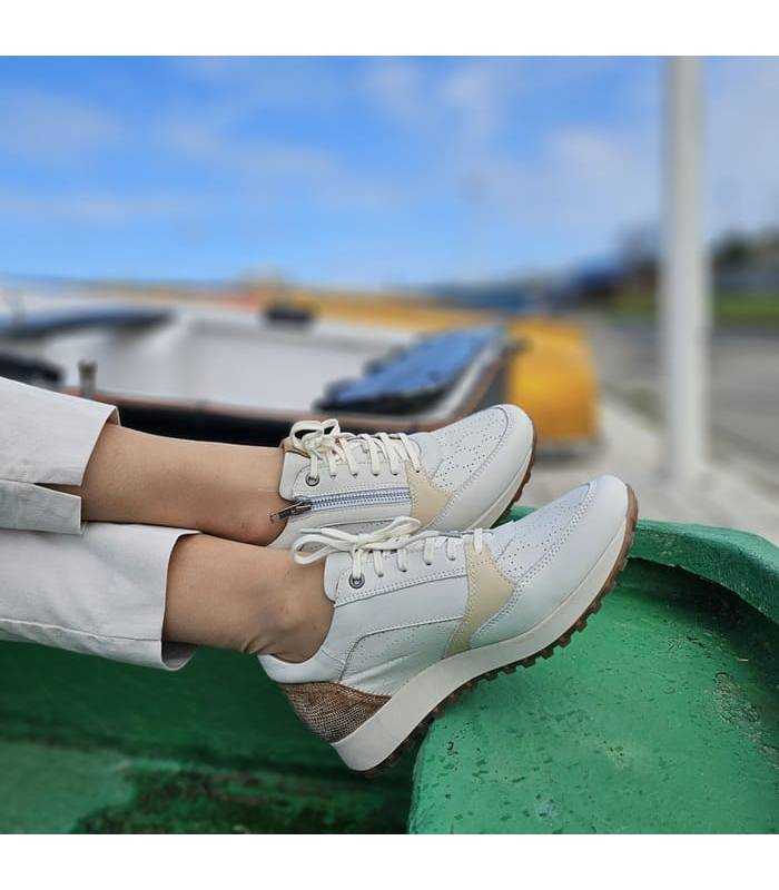 pies cruzados con los zapatos de piel beige con cremallera de Kangaroos