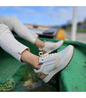 Zapato deportivo beige con cremallera de Kangarros puesto en modelo posando en una barca
